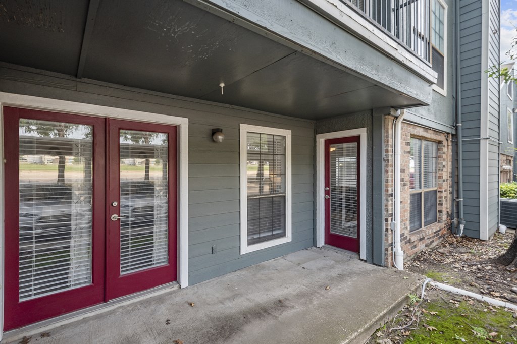 A house with red doors and a grey wall.