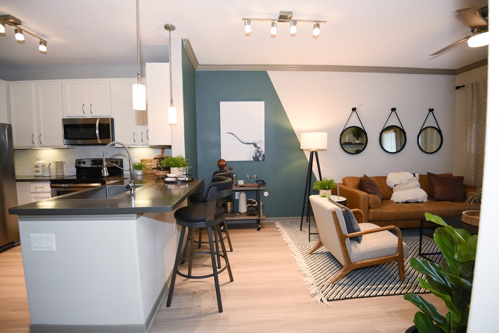 A modern kitchen with a bar stool and a chair.