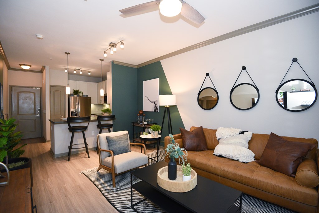 A living room with a brown couch, a white chair, and a black coffee table.