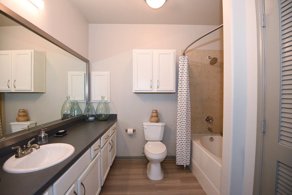 A bathroom with a sink, toilet, and bathtub.