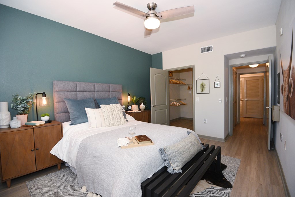 A bedroom with a bed, nightstands, and a ceiling fan.