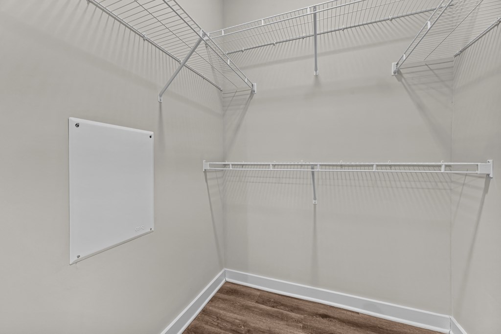 A white wall with a white board and a white shelf.