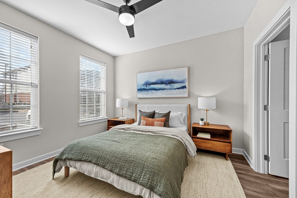 A bedroom with a bed, nightstands, and a ceiling fan.