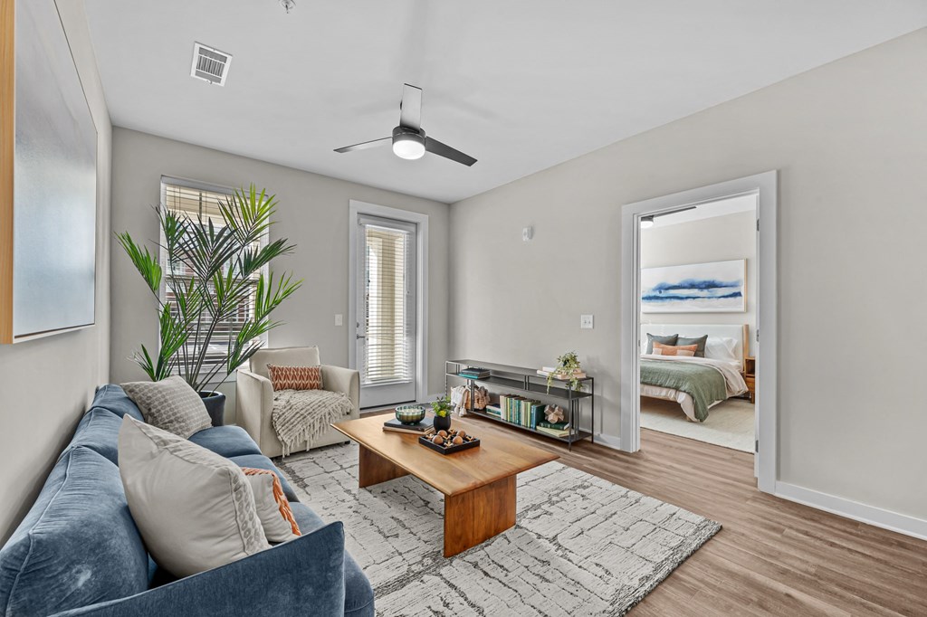 A living room with a blue couch and a wooden coffee table.