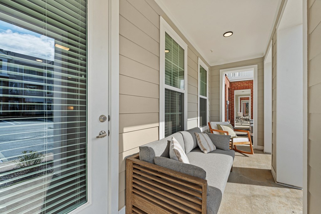 A modern living room with a grey couch and a wooden chair.