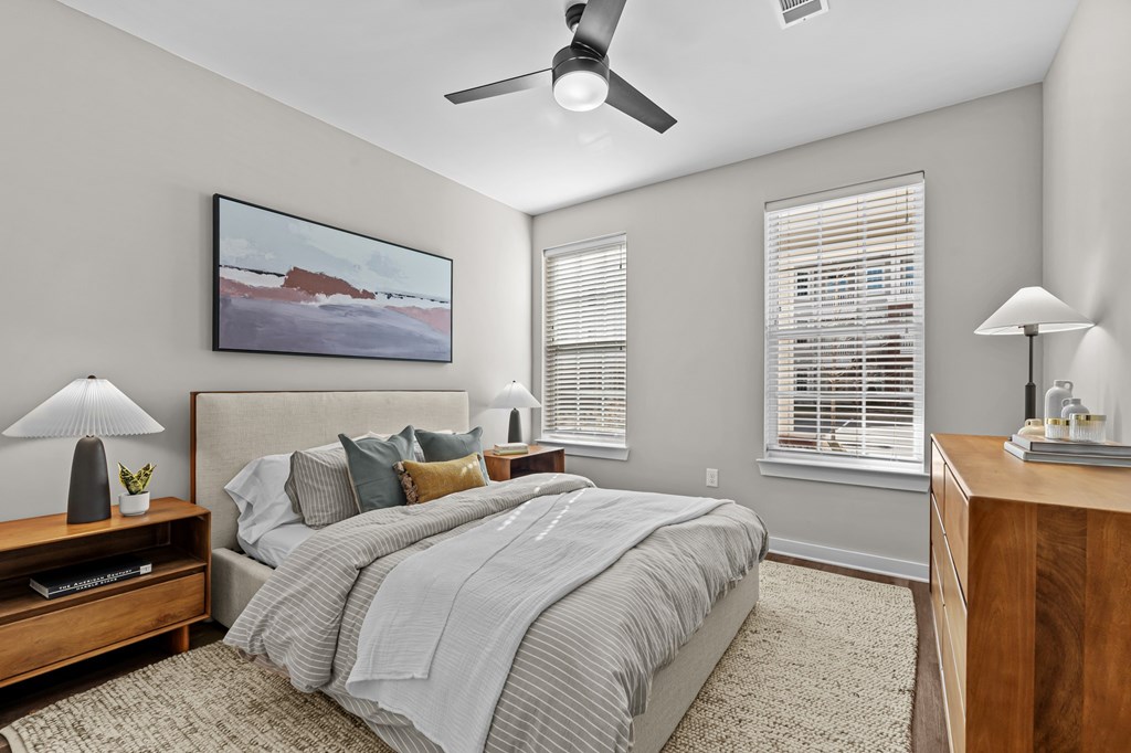 A bedroom with a large bed and a painting on the wall.