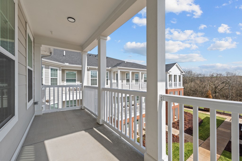 A balcony with white railings and a view of a residential area.