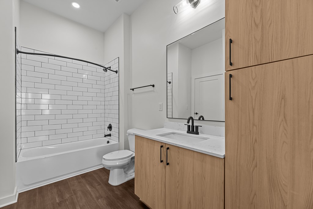 A bathroom with a white tub, sink, and toilet.