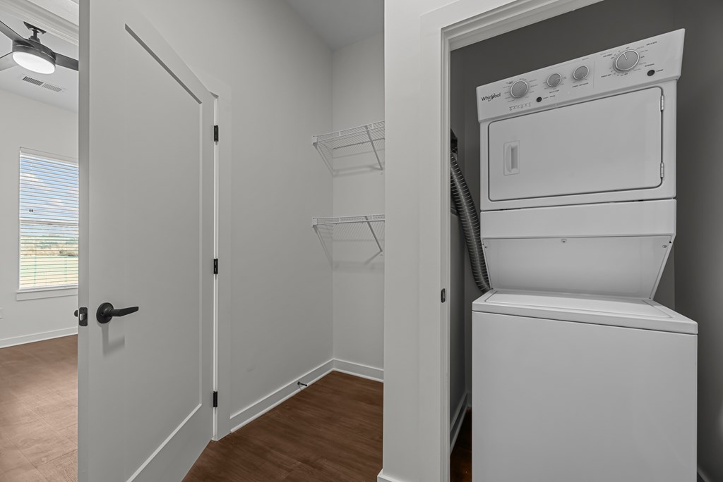 A white washing machine is in a small laundry room.