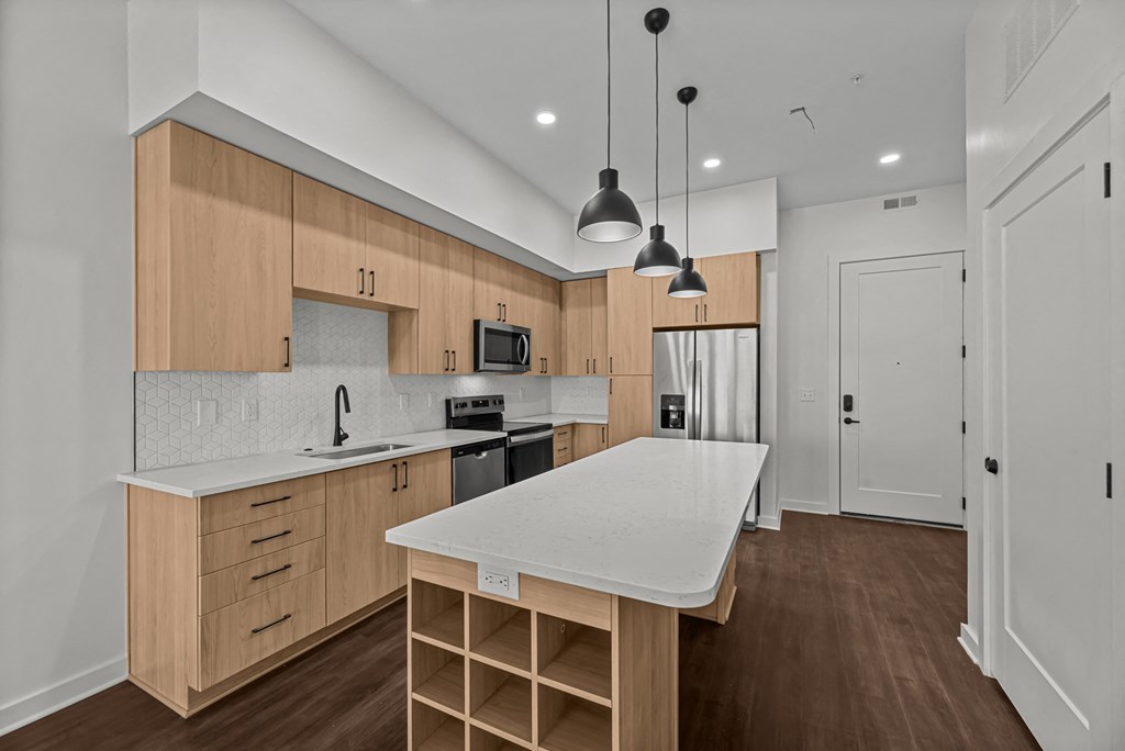 A modern kitchen with wooden cabinets and a white island.