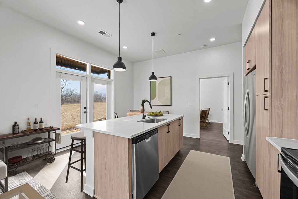 A modern kitchen with wooden cabinets and a large island.