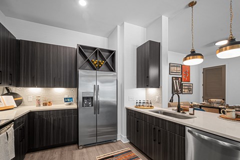 a kitchen with a stainless steel refrigerator and a sink