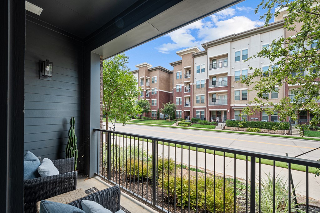 a balcony with a view of a street and some apartment buildings