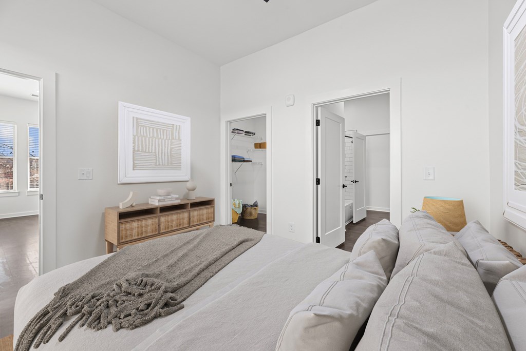 A bedroom with a large bed and a painting on the wall.