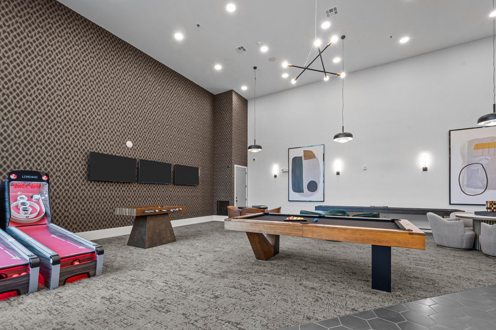 two pool tables in a room with televisions and other gaming equipment
