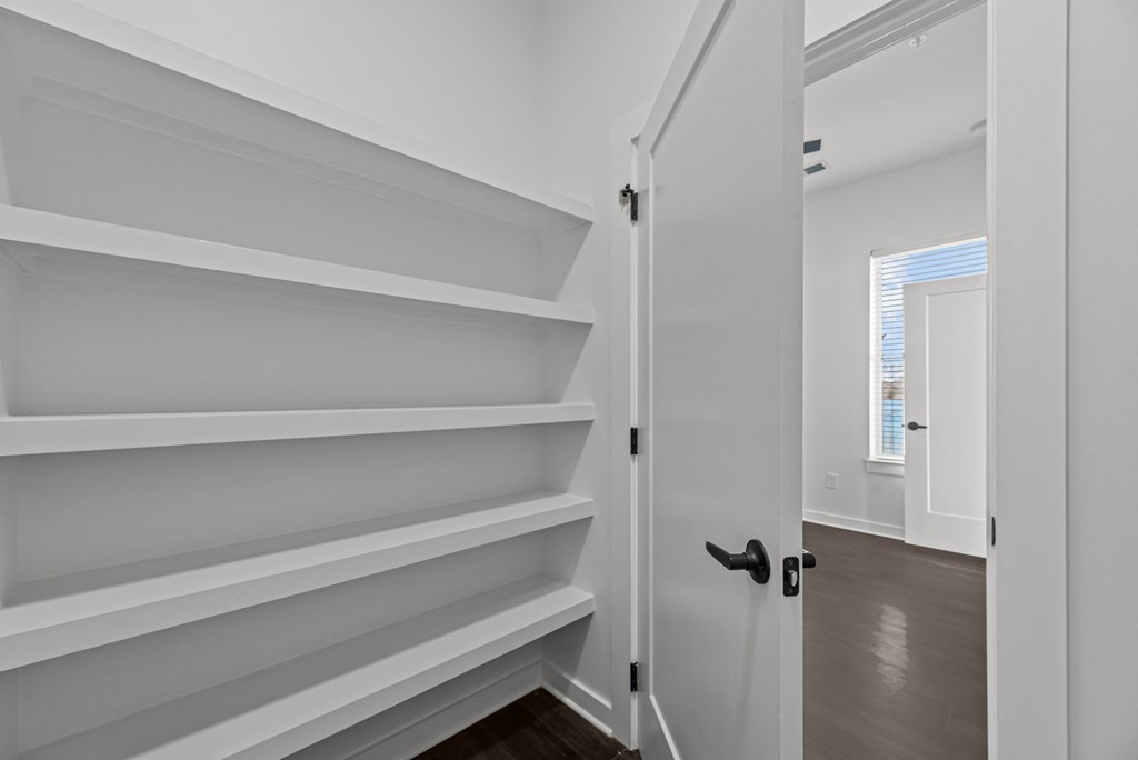 A white hallway with a black door and a black handle.