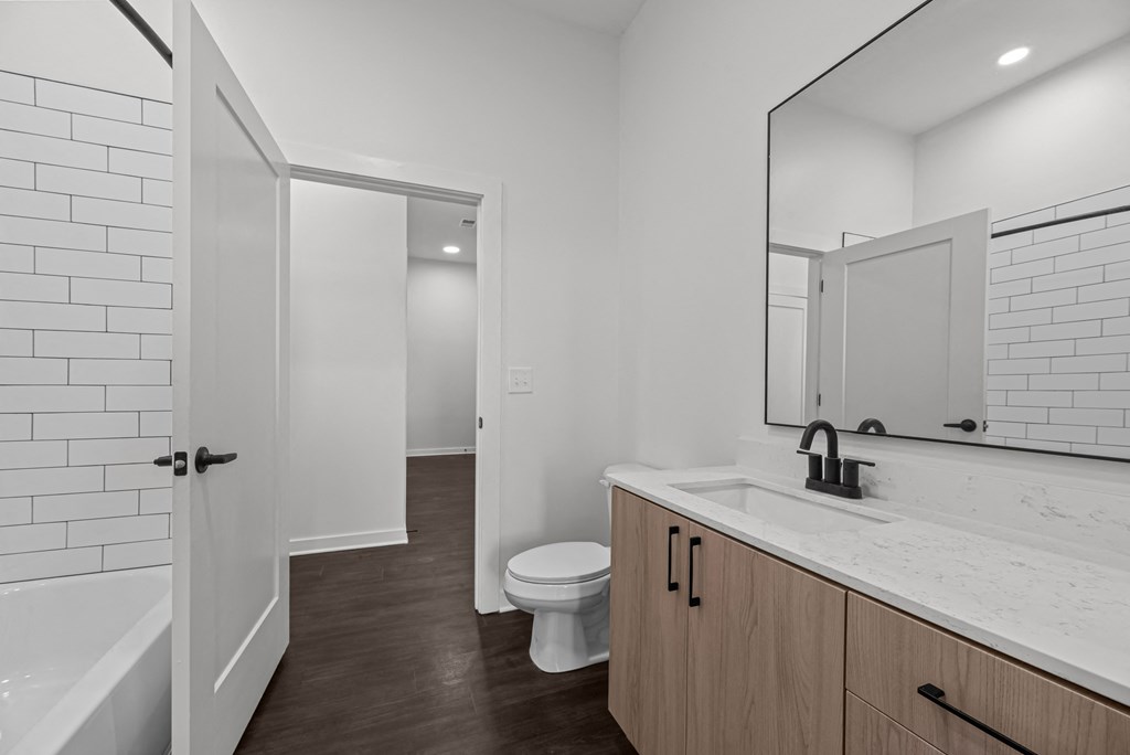 A white bathroom with a toilet, sink, and bathtub.