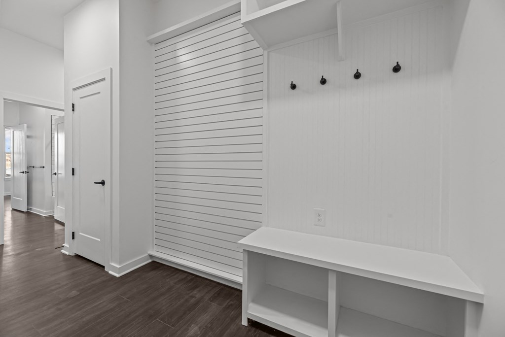 A white room with a bench and a door.