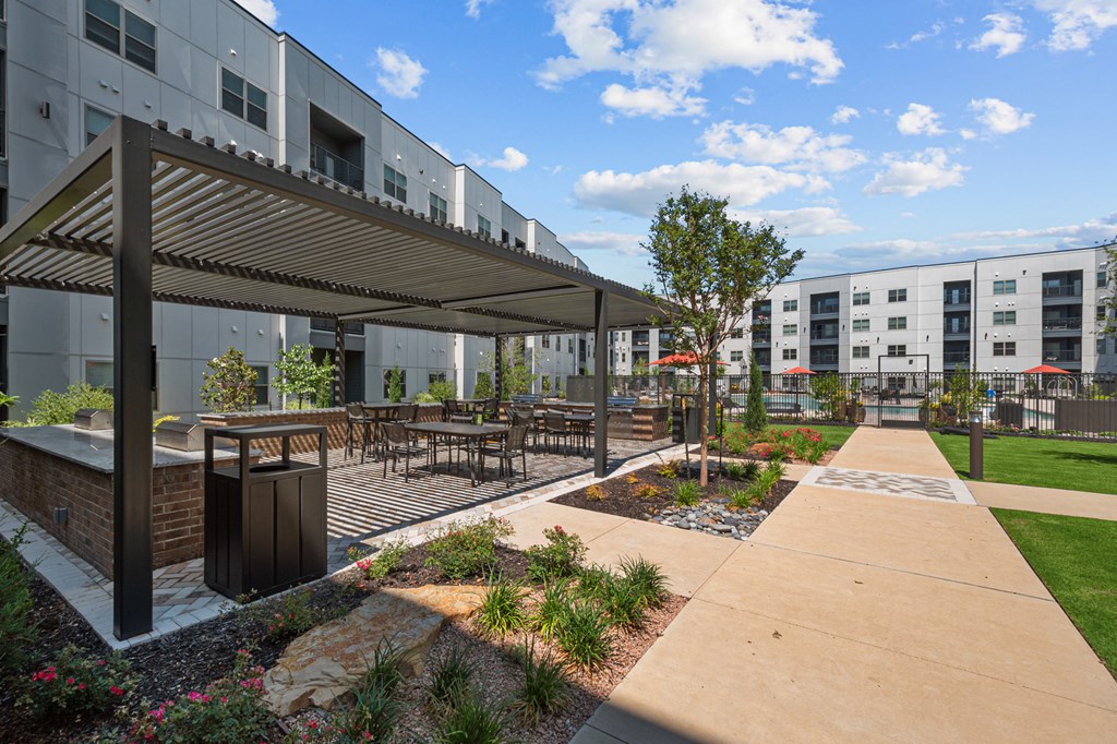 an outdoor patio with tables and chairs and a building in the background