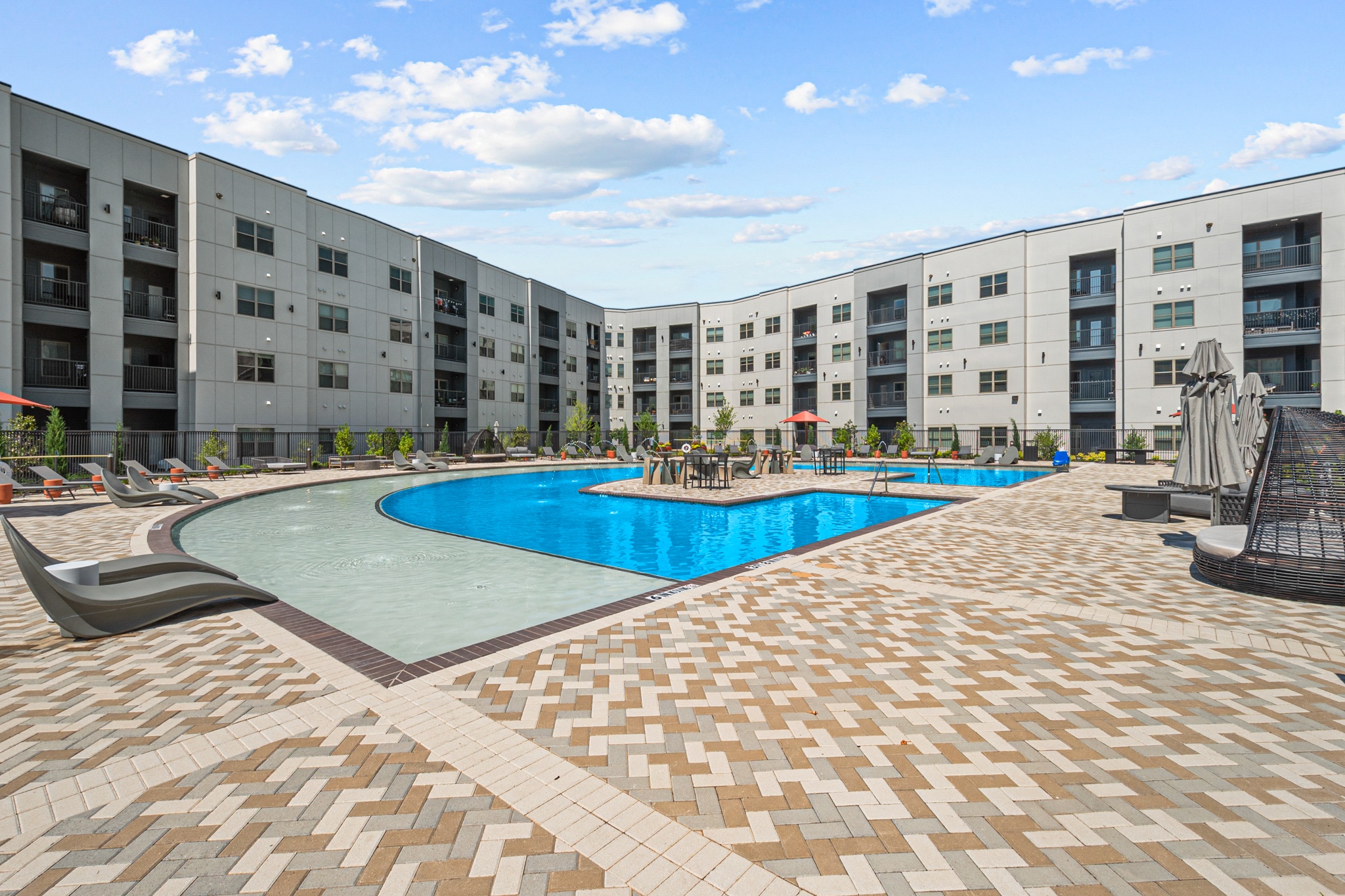 a large swimming pool in front of an apartment building