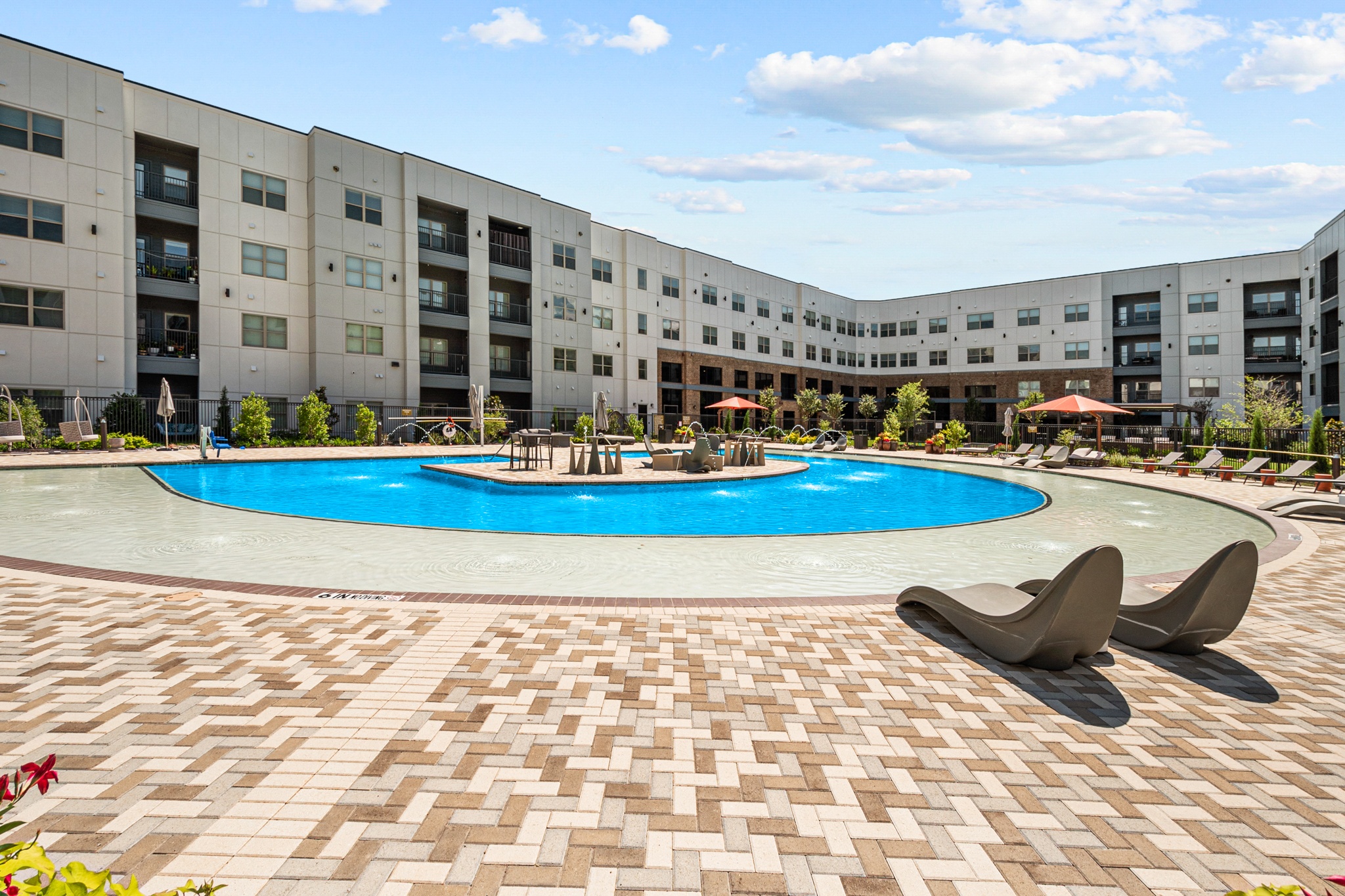 a large swimming pool in front of an apartment building