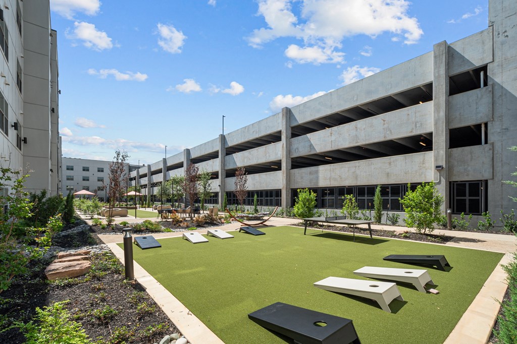 a courtyard with picnic tables and grass in front of an office building