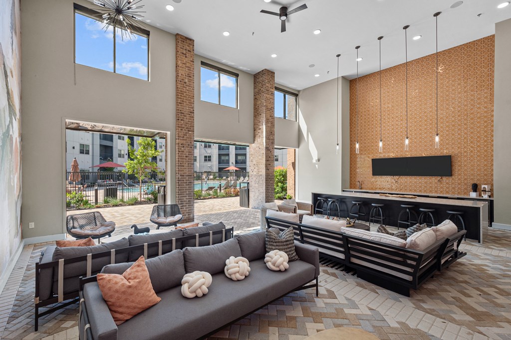 a large lobby with couches and chairs and a bar and windows