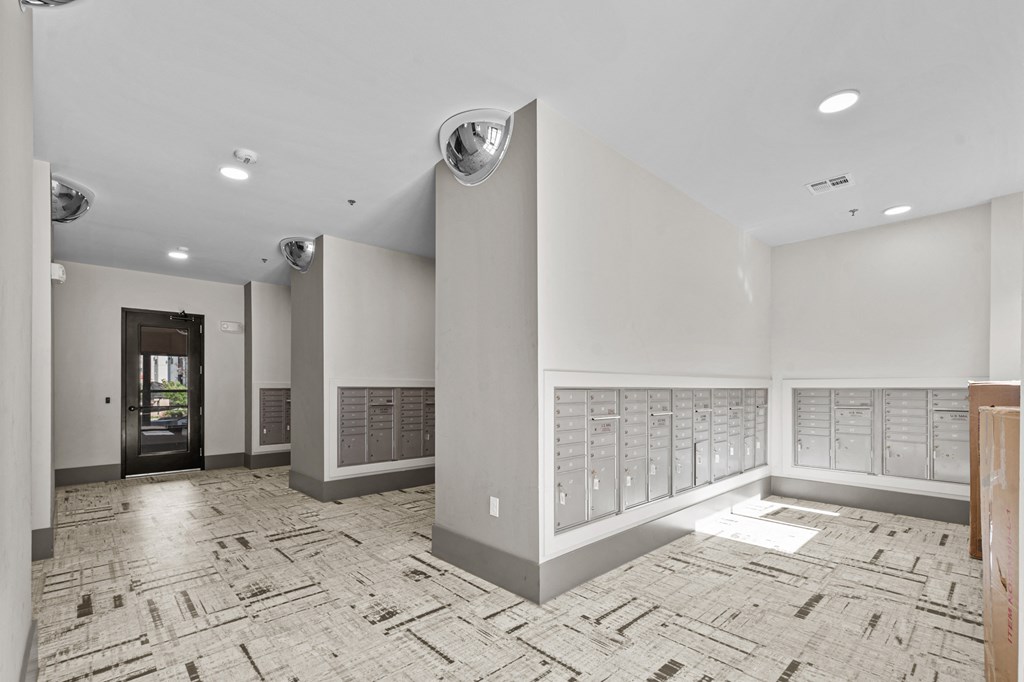 a large room with a wall of mailboxes and a door to a building