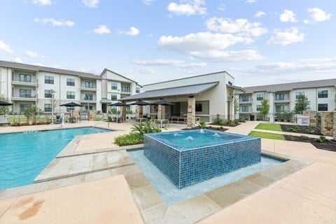 A swimming pool in front of apartment buildings.