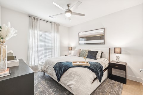 A bedroom with a large bed and a ceiling fan.