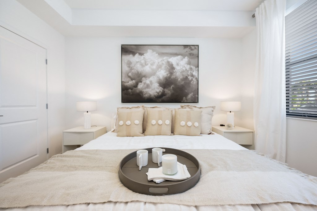 a bedroom with a large bed and a painting on the wall