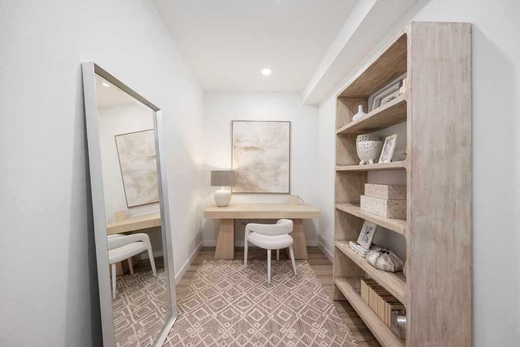a home office with a desk and a mirror