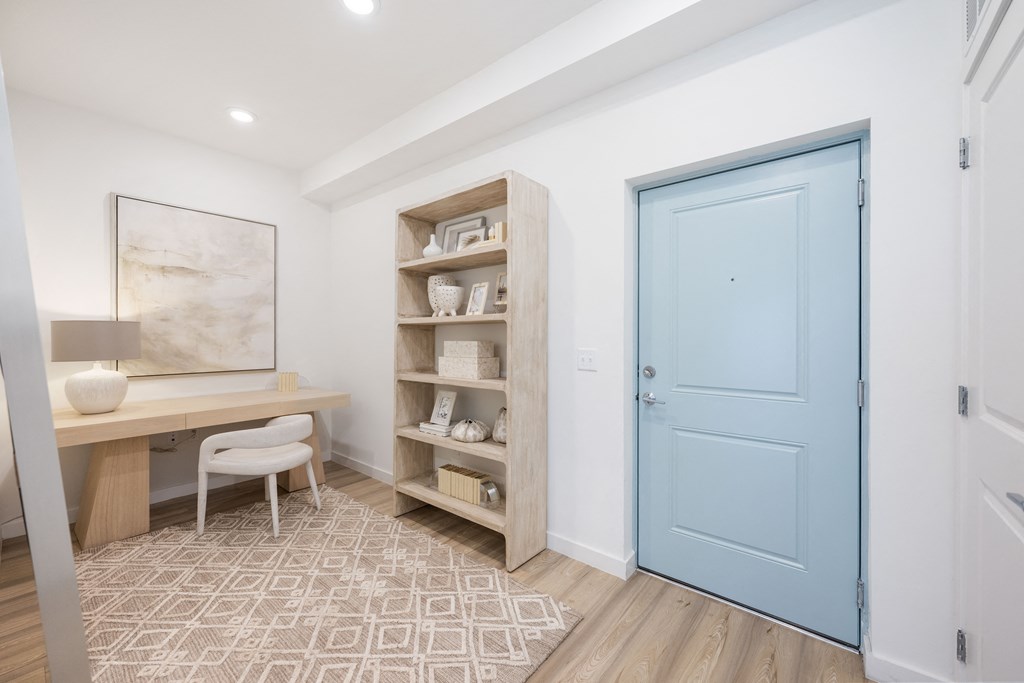 a home office with a desk and chair and a blue door