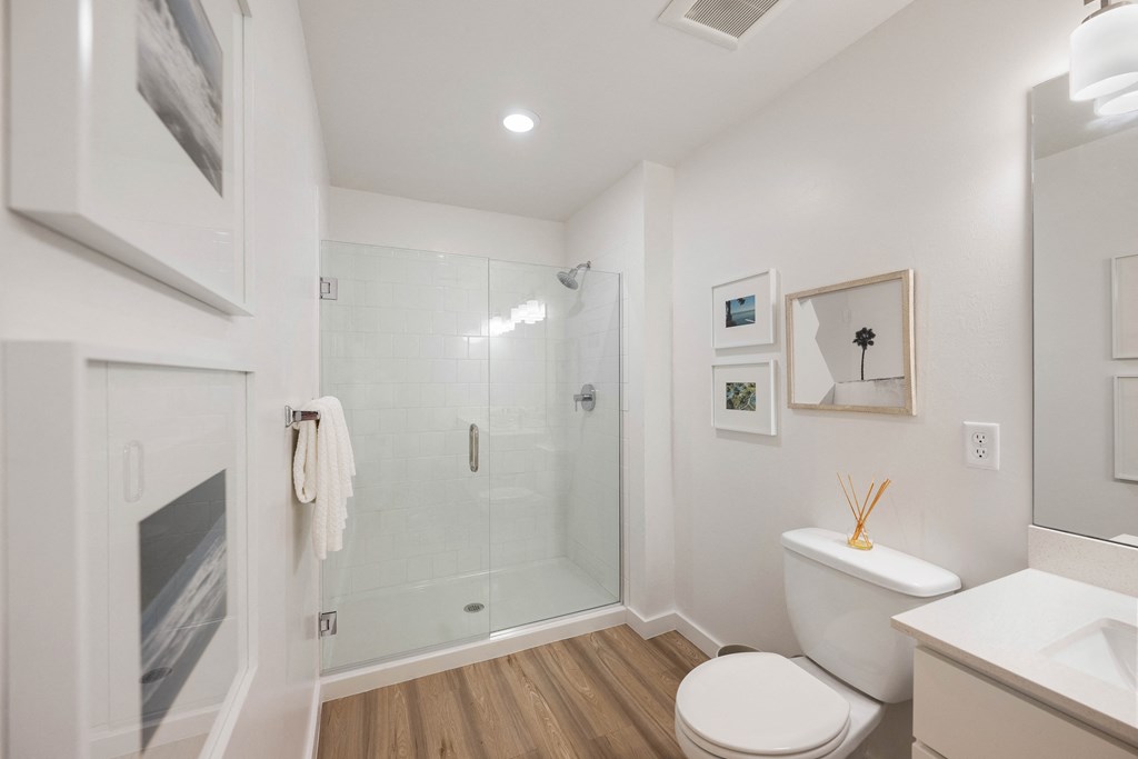 a bathroom with a white toilet and a glass shower