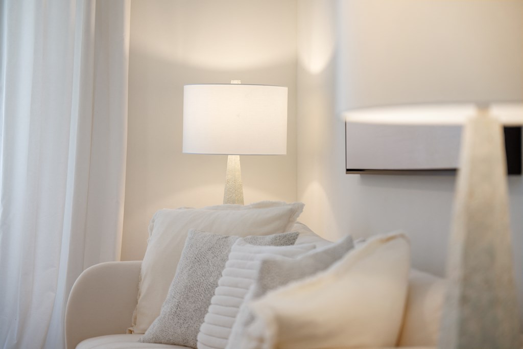 white couch with white pillows and a white lamp