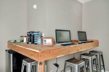 A wooden table with two laptops and a picture frame on it.