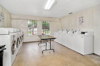 A laundry room with a table and washing machines.