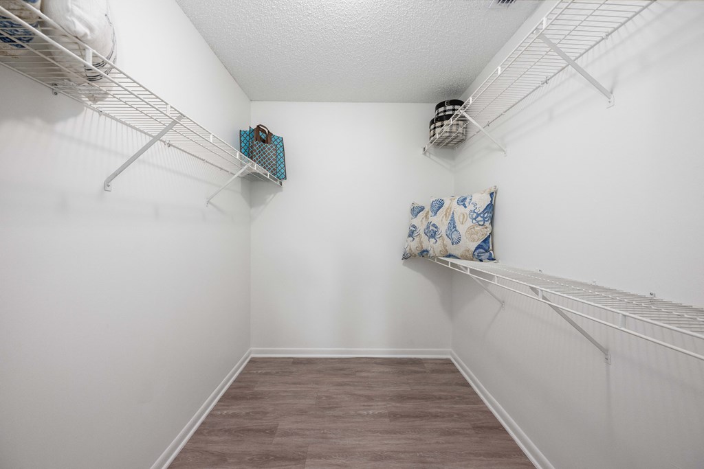 a spacious room with white walls and two shelves on the wall and a closet with