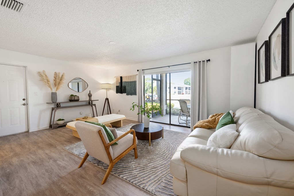 a living room with a white couch and a sliding glass door