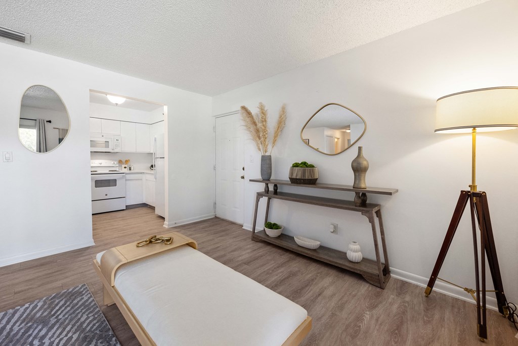 a bedroom with a bed and a lamp and a kitchen