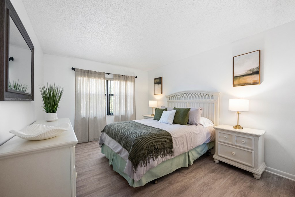 a bedroom with a bed and a dresser and a window