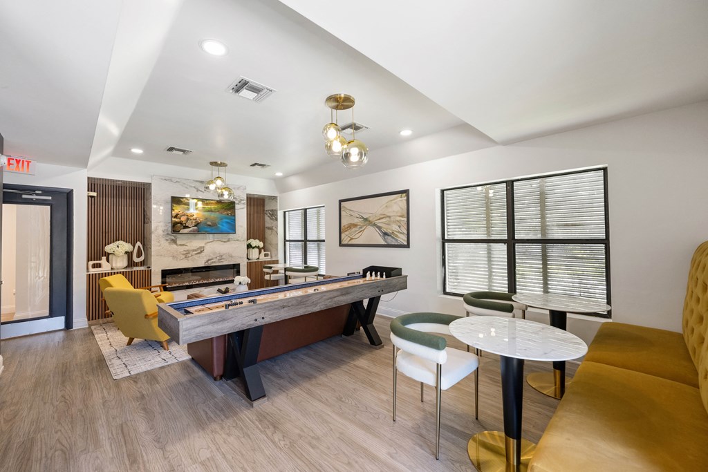 a game room with a pool table and chairs