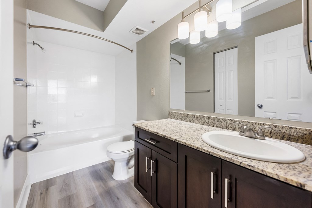 a bathroom with a large mirror and a sink and a toilet