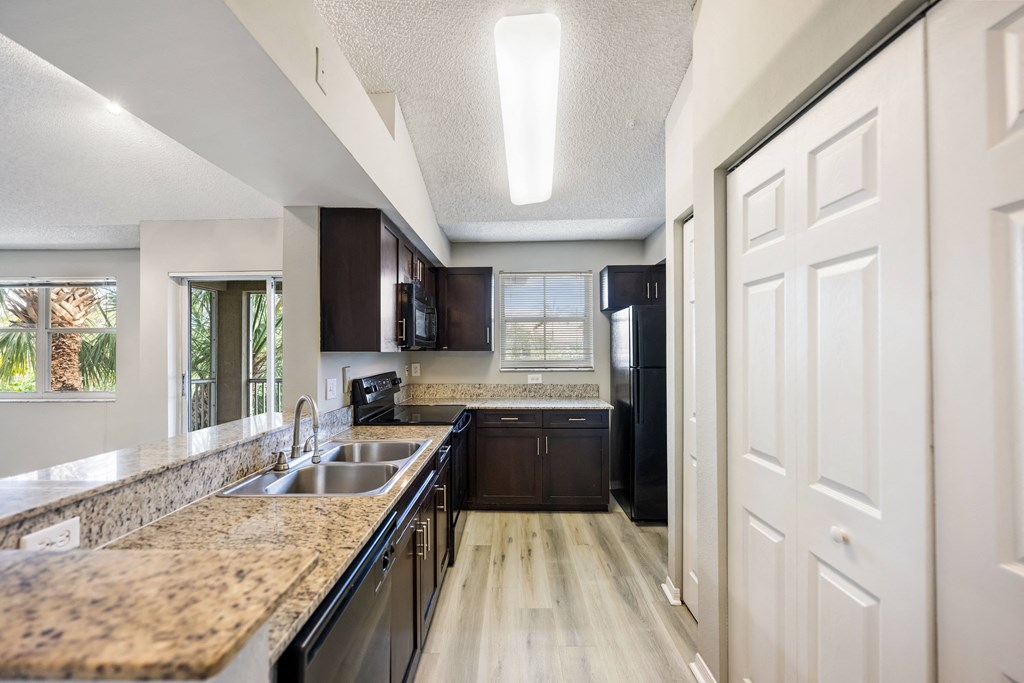 an open kitchen with granite counter tops and black appliances