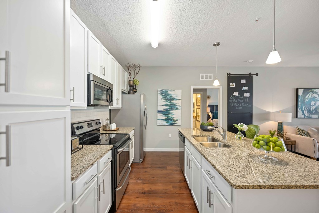 a kitchen with white cabinets and granite countertops