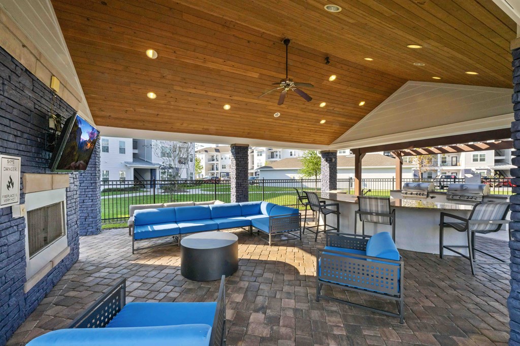 a covered patio with couches and a fireplace