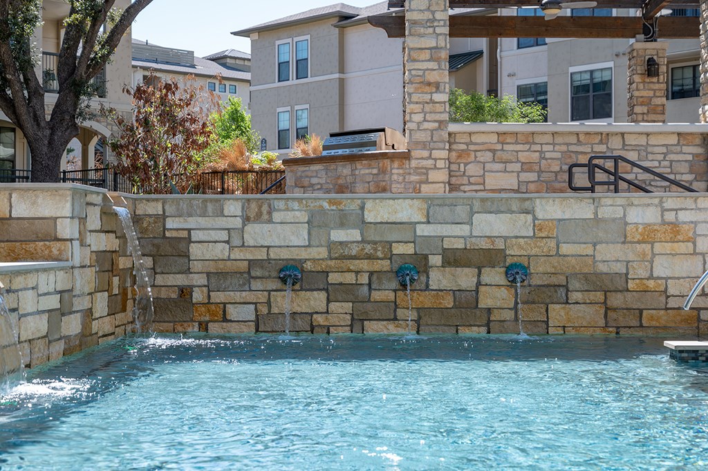 A pool with a waterfall feature in the middle of it.