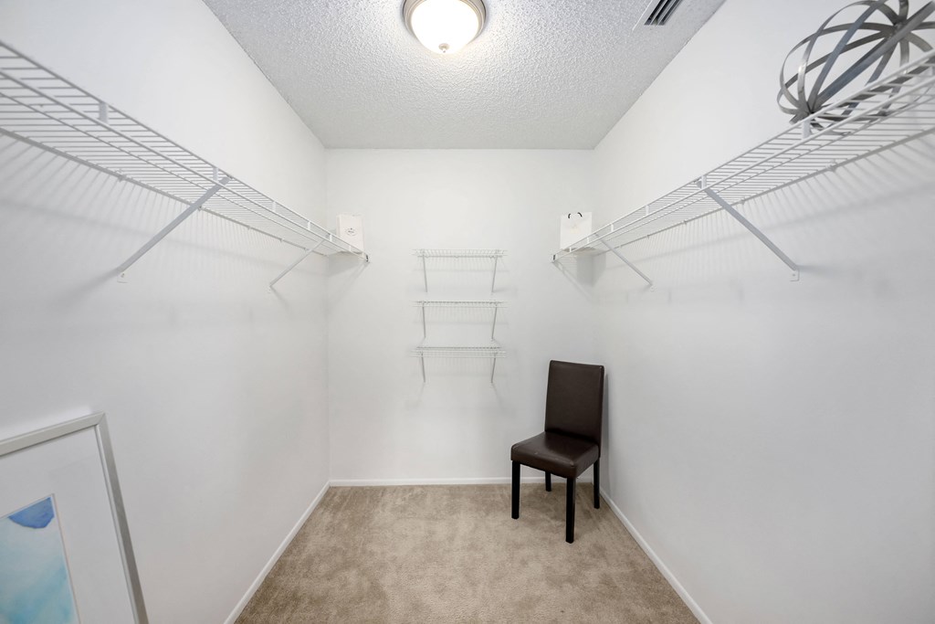 a bedroom with white walls and a white chair in the corner of the room