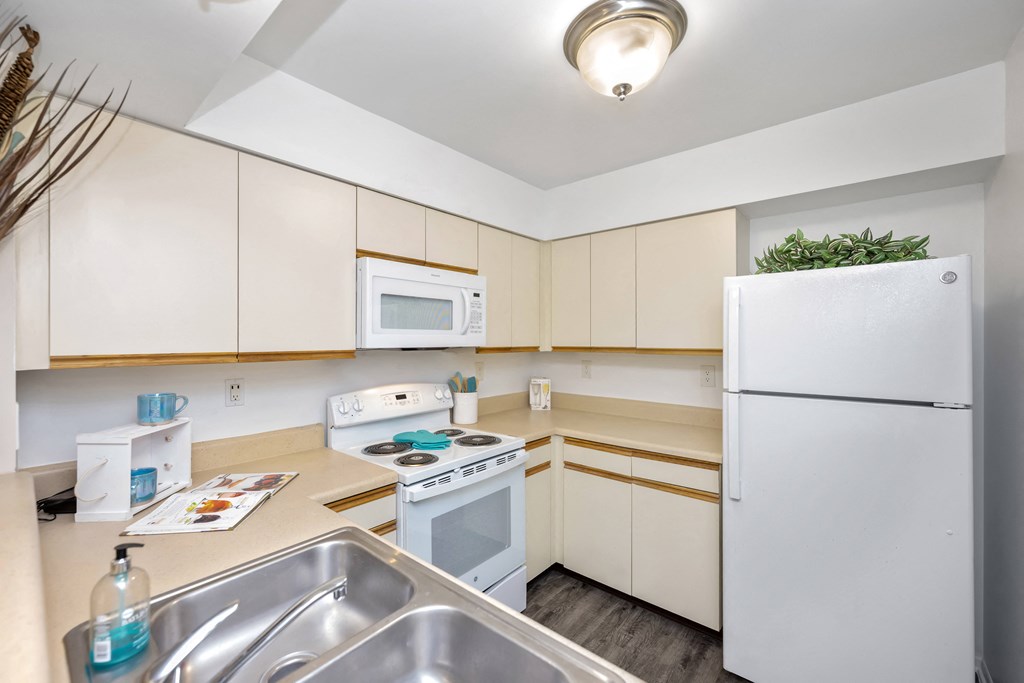 a kitchen with a white refrigerator freezer next to a stove top oven