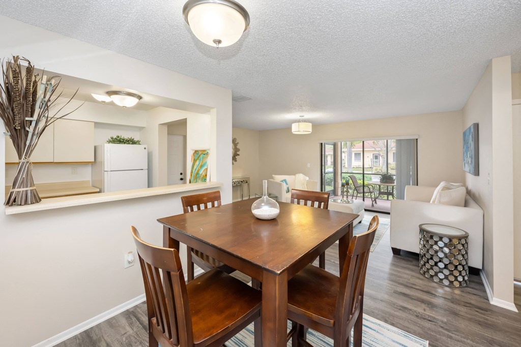 a dining area with a wooden table and chairs and a living room with a couch and a